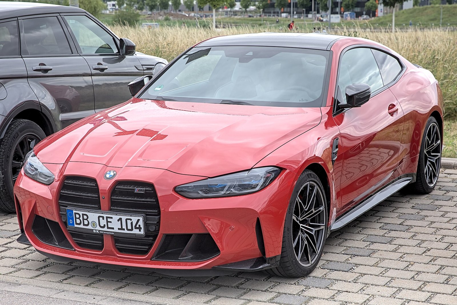 Красный BMW M4 Competition, вид три четверти спереди