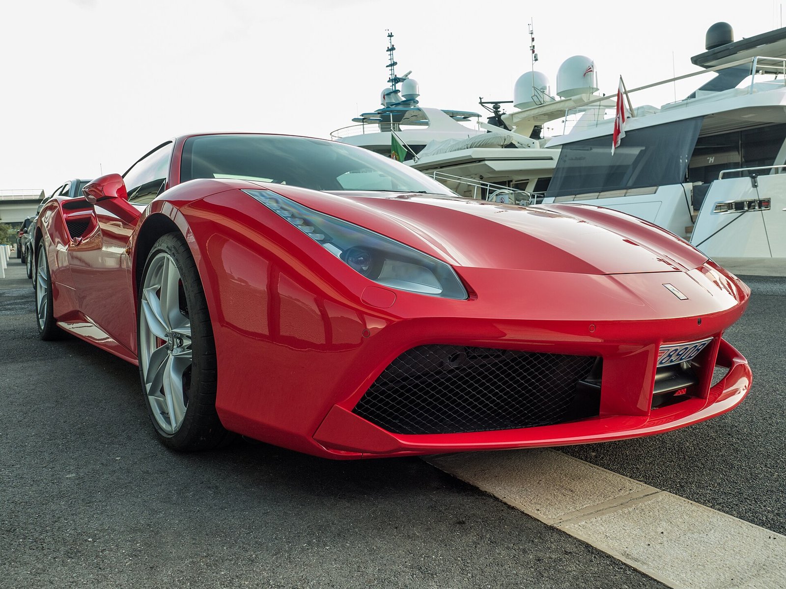 Красный Ferrari 488 у яхтенной гавани, вид спереди